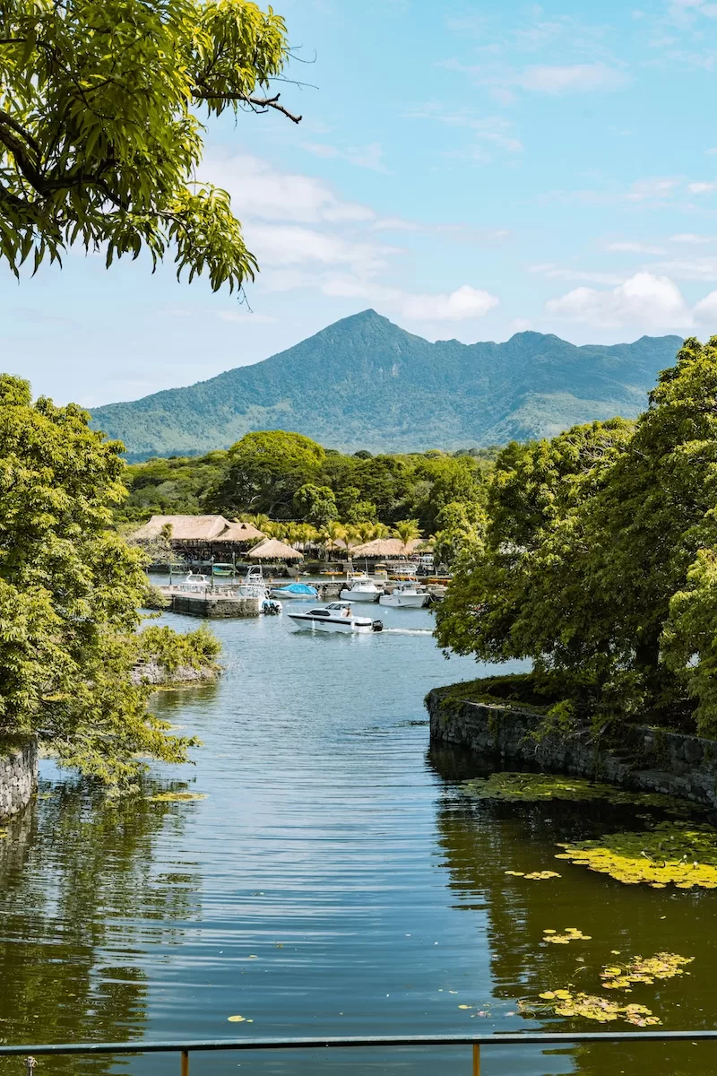 Waterway and tropical landscape in Nicaragua with boats and green mountains in the distance