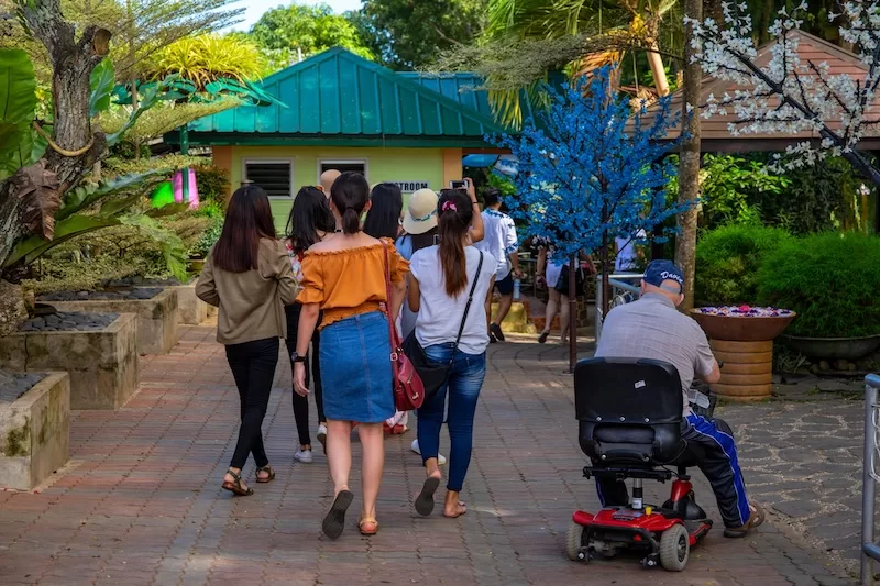Visitors walking through a tropical garden in the Philippines