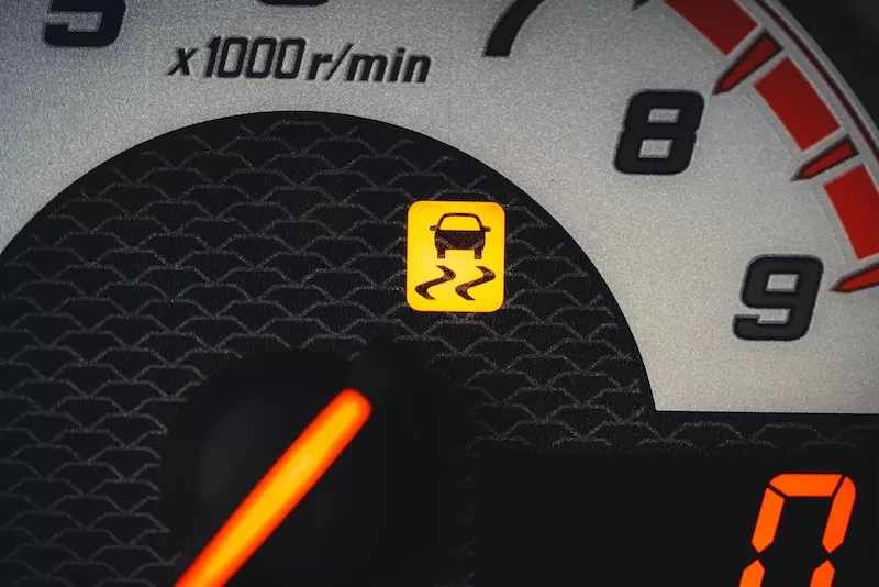 Vehicle dashboard with warning symbol lit, representing strain and disruption in transport systems