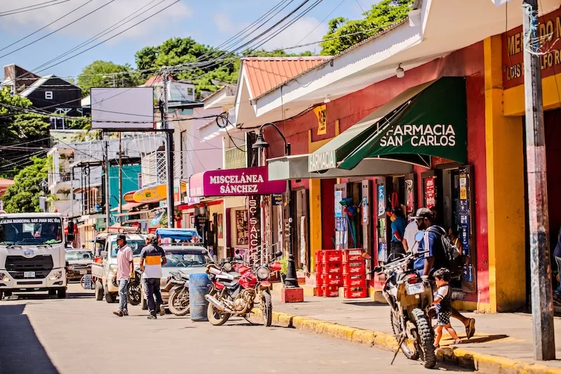 Colorful street in San Juan del Sur with shops, motorcycles, and local daily life in Nicaragua