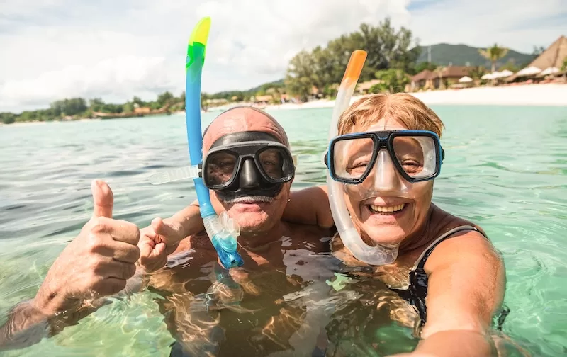 Retired couple snorkeling in clear tropical water
