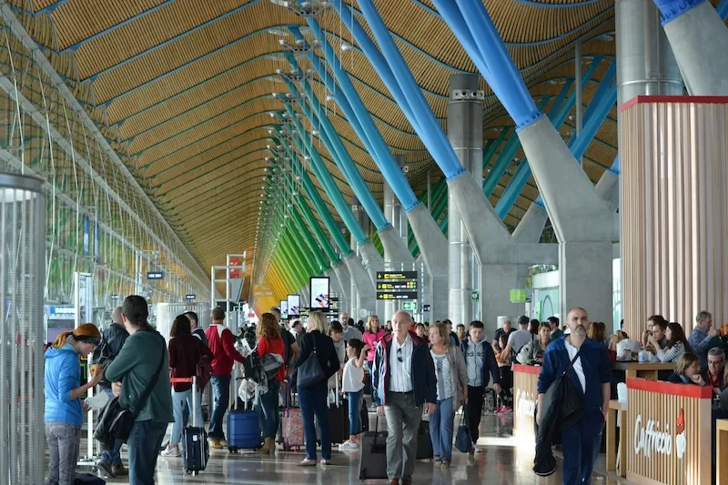 Busy airport terminal with travelers moving through a large departure concourse