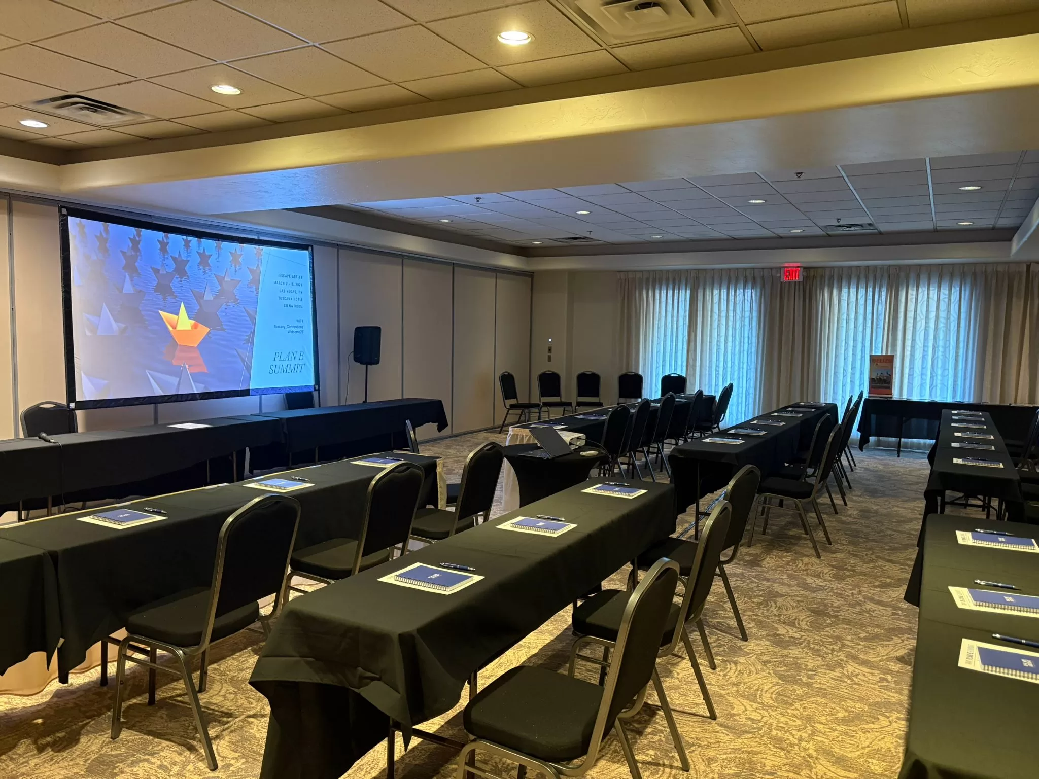 Conference room prepared for Plan B Summit sessions in Las Vegas with tables, chairs, and presentation screen