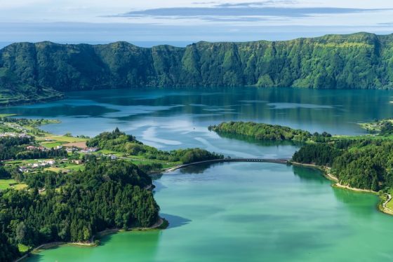 Volcanic crater lake in the Azores surrounded by green hills and forest