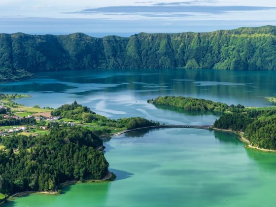 Volcanic crater lake in the Azores surrounded by green hills and forest