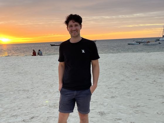 Christopher Nash standing on Kendwa Beach in Zanzibar at sunset.