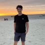 Christopher Nash standing on Kendwa Beach in Zanzibar at sunset.