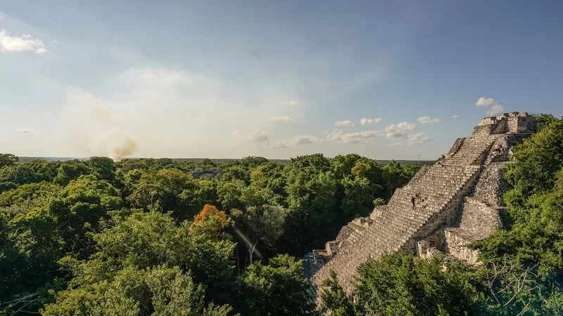 Ancient Maya pyramid rising above dense jungle in Calakmul, Mexico