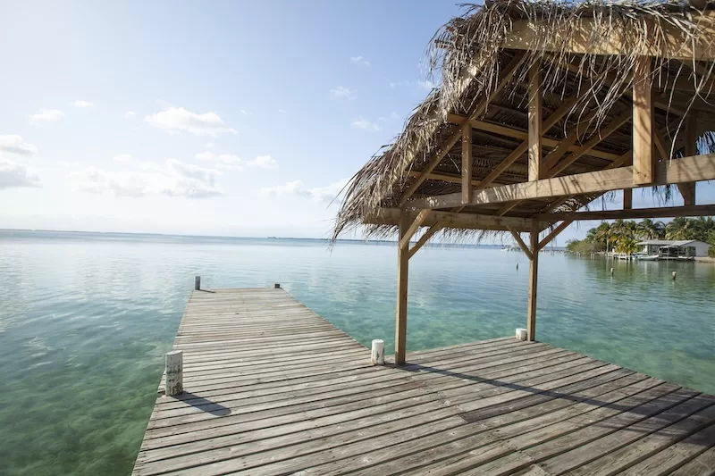 Wooden dock extending into clear Caribbean waters in Belize