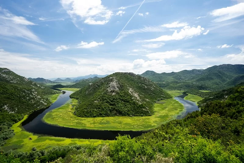 Green river valley and mountain landscape in Montenegro under a blue sky
