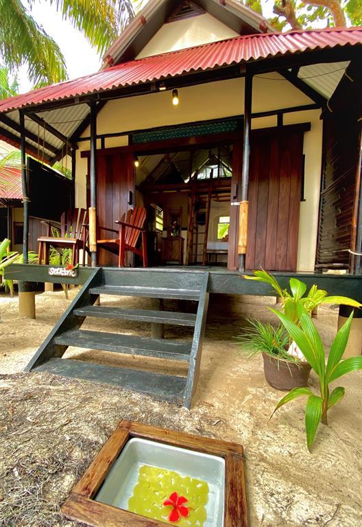 Raised Caribbean resort bungalow with wooden porch and entrance steps