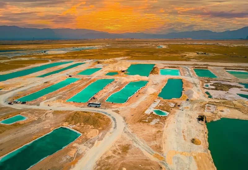 Aerial view of turquoise desert pools and salt flats at sunset