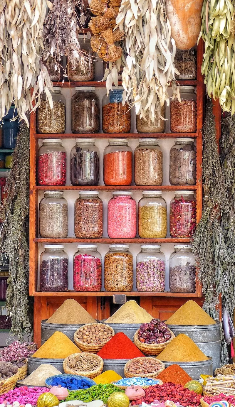 Colorful Moroccan spice market with jars, herbs, and dried goods