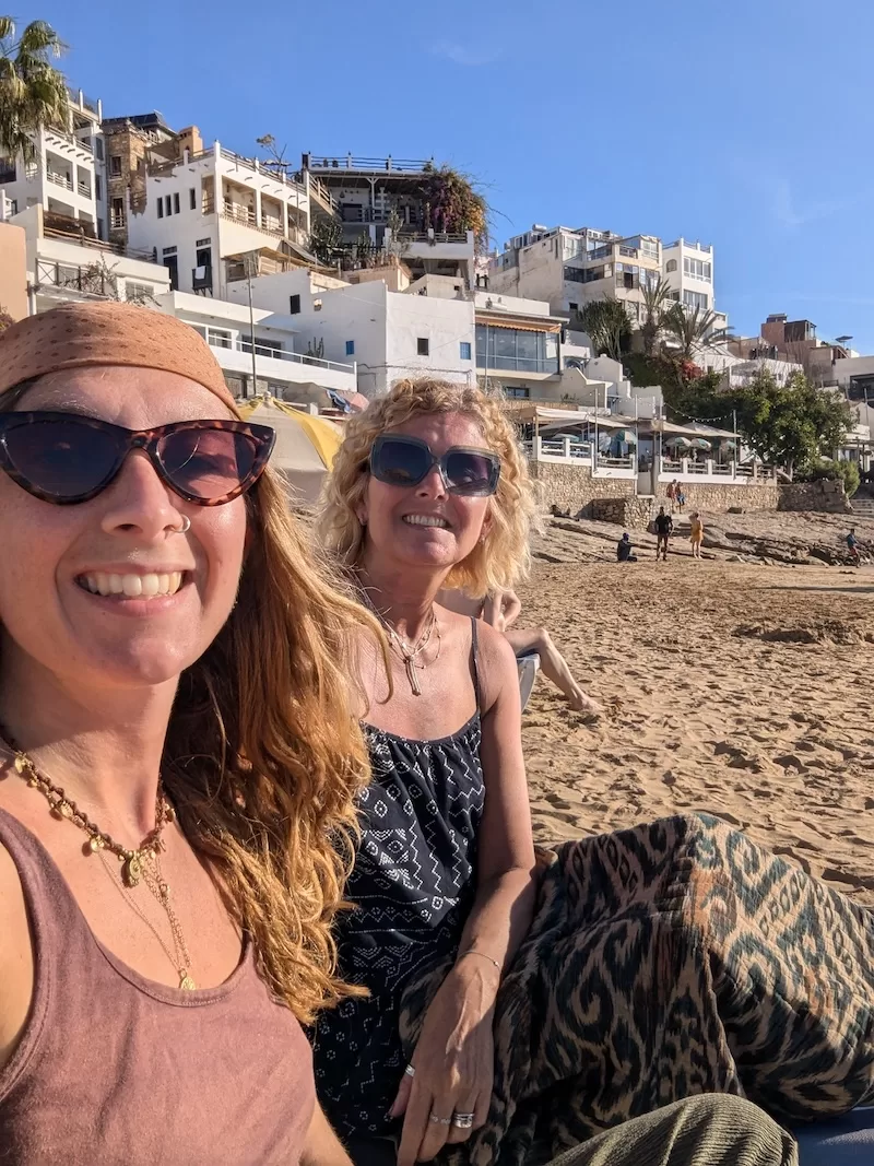 Two women smiling on a beach in Morocco