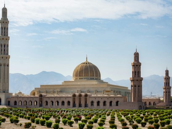 Qaboos Grand Mosque in Muscat Oman with mountains in the background