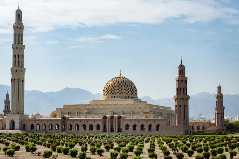 Qaboos Grand Mosque in Muscat Oman with mountains in the background