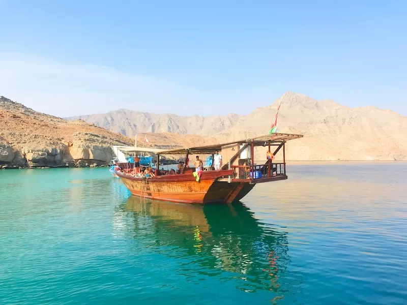 Traditional dhow boat on turquoise water in Musandam Oman