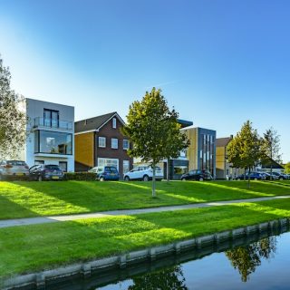 Modern residential homes beside a canal in a quiet property market