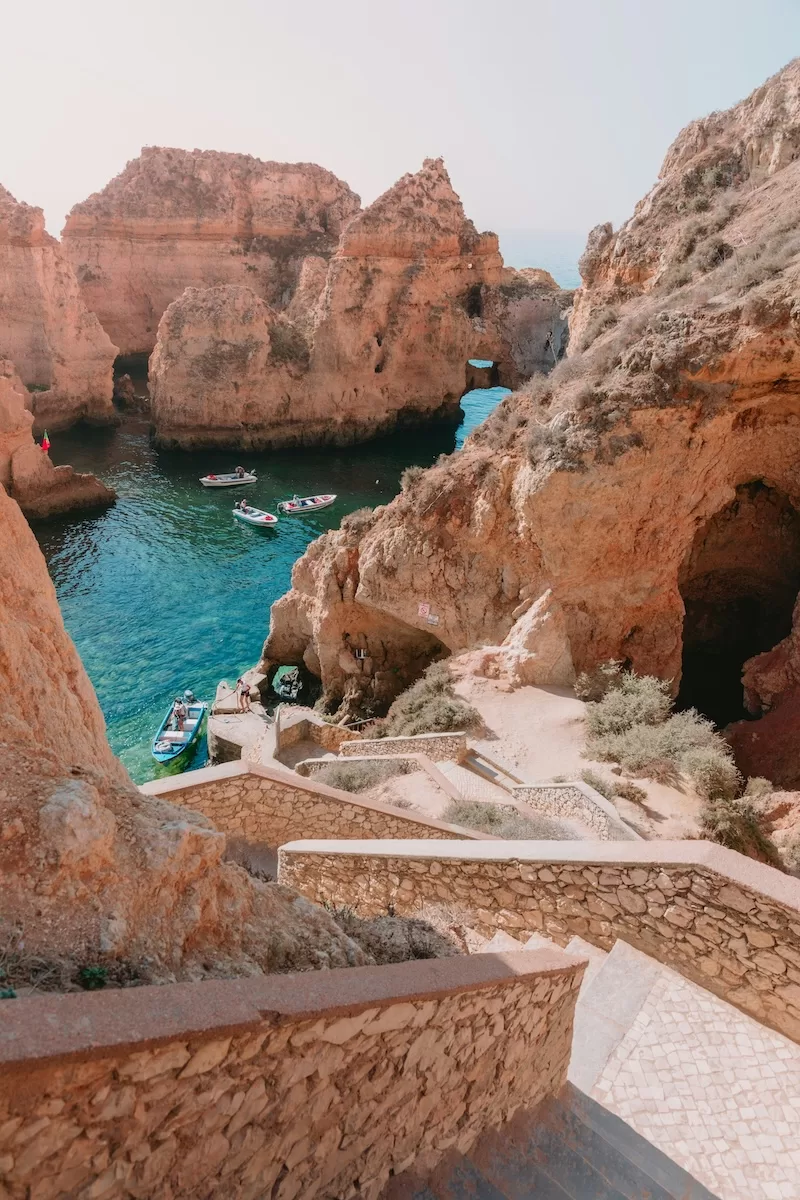Rock formations and sea caves with small boats in the turquoise water near Ponta da Piedade, Portugal