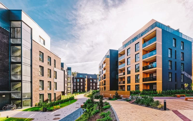 Modern apartment buildings with balconies and landscaped paths between them