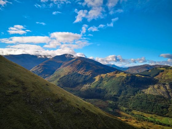 Remote mountain landscape beneath a blue sky and scattered clouds