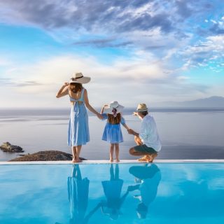 Family beside an infinity pool overlooking the sea