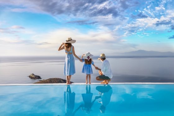 Family beside an infinity pool overlooking the sea