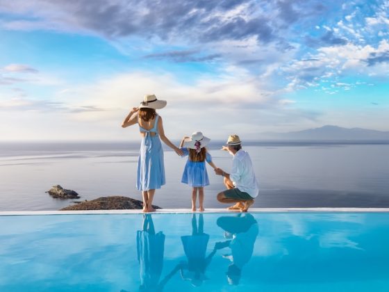 Family beside an infinity pool overlooking the sea