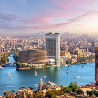Cairo skyline and Nile River with boats and high-rise buildings