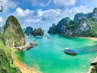 Turquoise bay with tour boats surrounded by limestone karst formations in Ha Long Bay, Vietnam