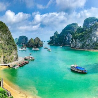 Turquoise bay with tour boats surrounded by limestone karst formations in Ha Long Bay, Vietnam