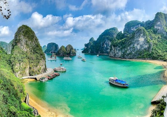 Turquoise bay with tour boats surrounded by limestone karst formations in Ha Long Bay, Vietnam