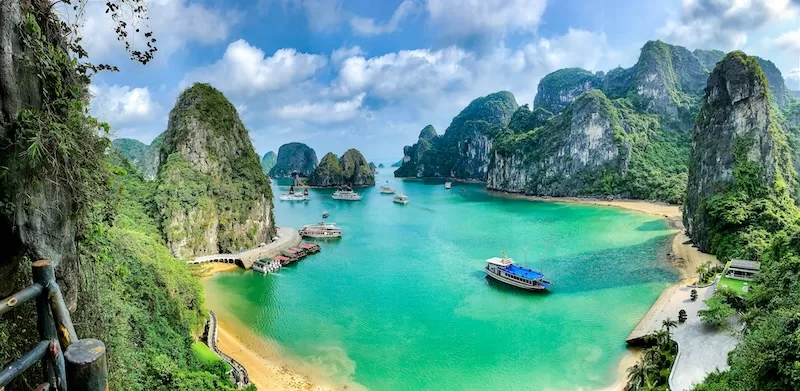 Turquoise bay with tour boats surrounded by limestone karst formations in Ha Long Bay, Vietnam