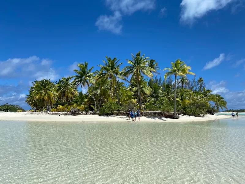 Tropical island with coconut palms, white sand and shallow clear water