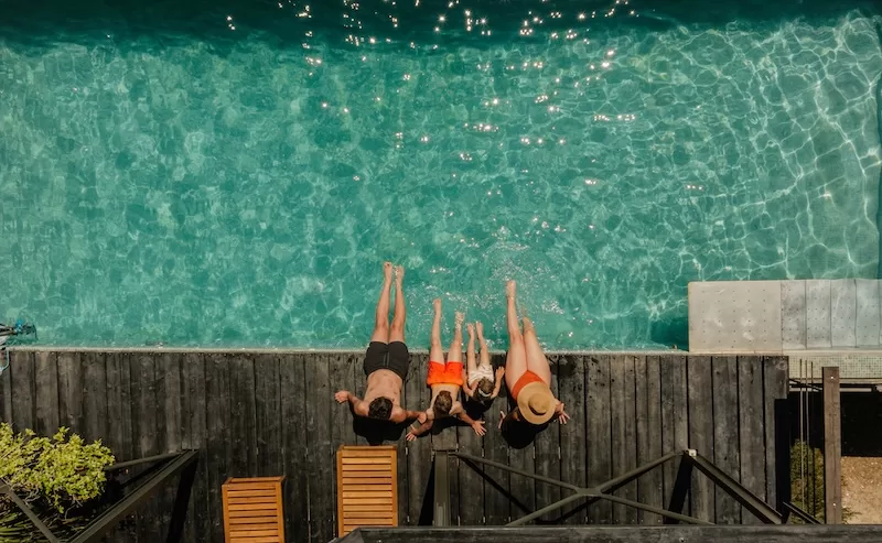 Family sitting together beside a swimming pool