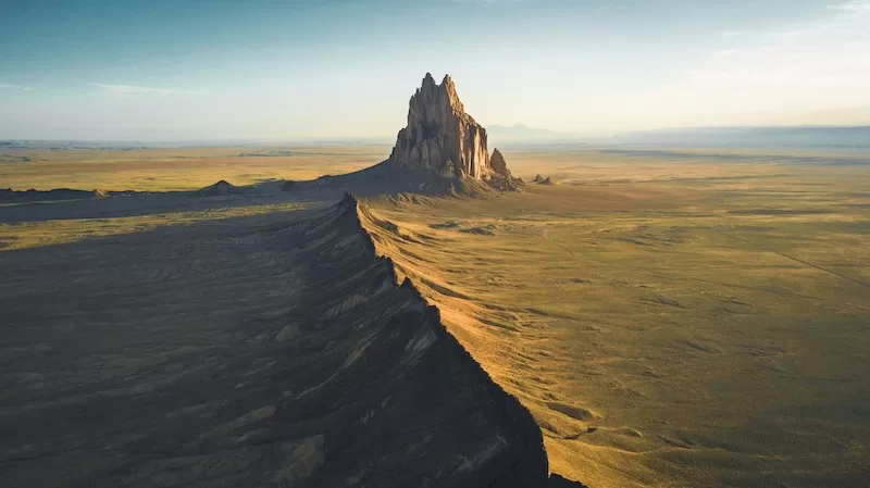 Rock formation rising above a remote desert landscape in the American Southwest