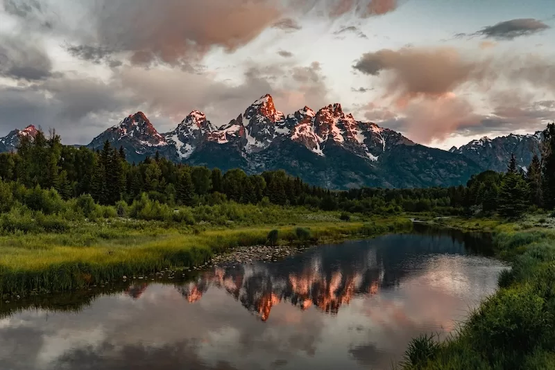 Snow-covered mountain range reflected in a calm lake in Wyoming