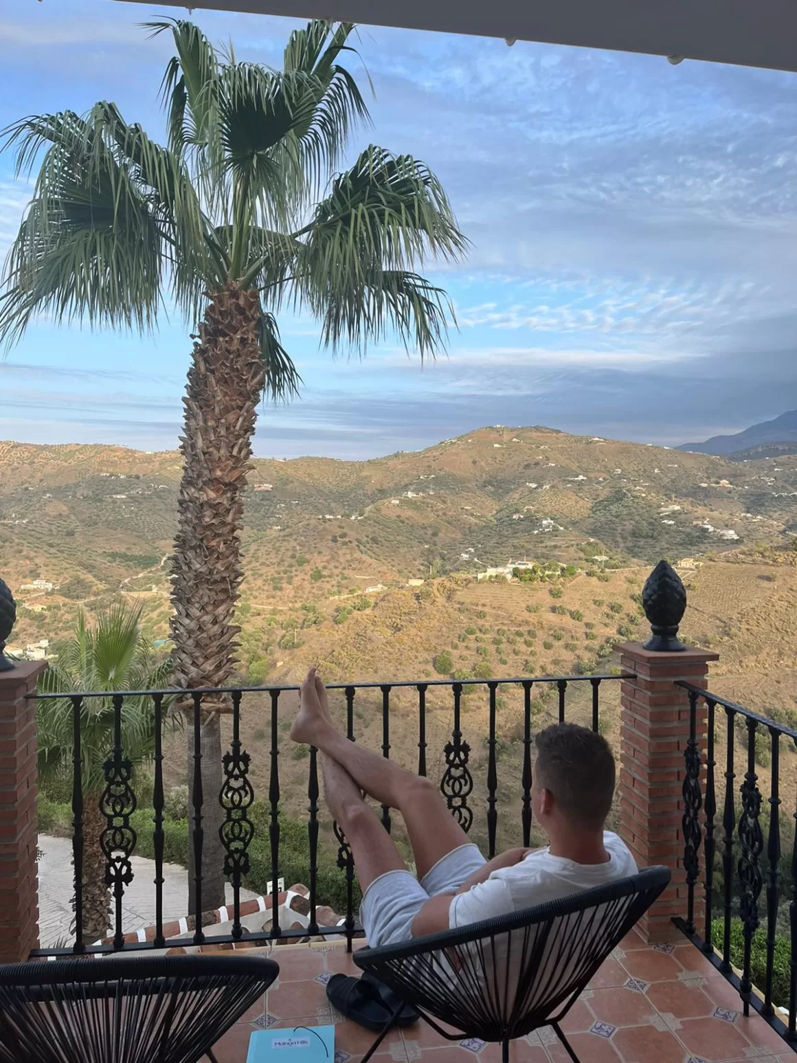 Man relaxing on a terrace overlooking the mountains near Cómpeta, Spain