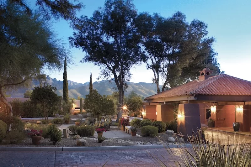 Desert garden pathway and lit entrance at the Canyon Ranch Tucson resort at dusk