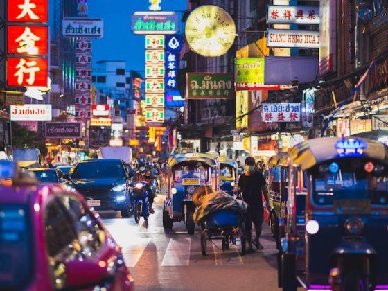 Tuk tuks, taxis and neon signs crowd a Bangkok Chinatown street at night