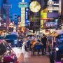 Tuk tuks, taxis and neon signs crowd a Bangkok Chinatown street at night
