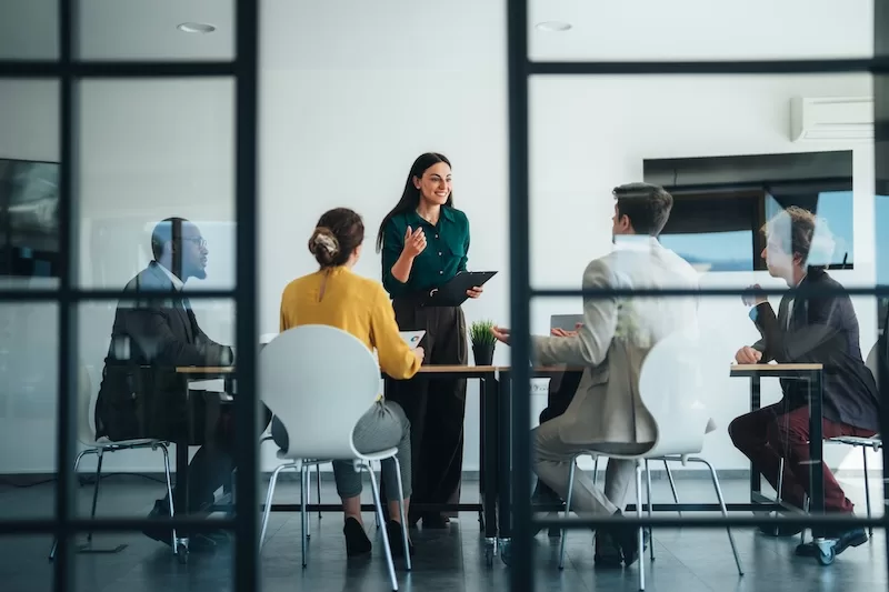 Advisors in a meeting room discussing an application, the stage where jurisdiction, fees and timeline are actually decided.