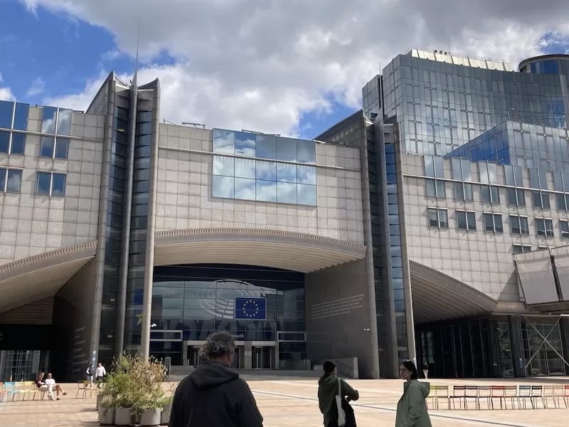The entrance of the European Parliament in Brussels under a cloudy sky
