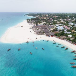 Aerial view of Kendwa beach on Zanzibar’s northwest coast, with dhow boats moored in shallow turquoise water