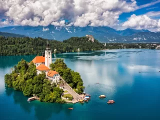 The island church and Bled Castle on Lake Bled, Slovenia, with the Julian Alps behind