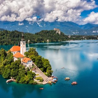 The island church and Bled Castle on Lake Bled, Slovenia, with the Julian Alps behind