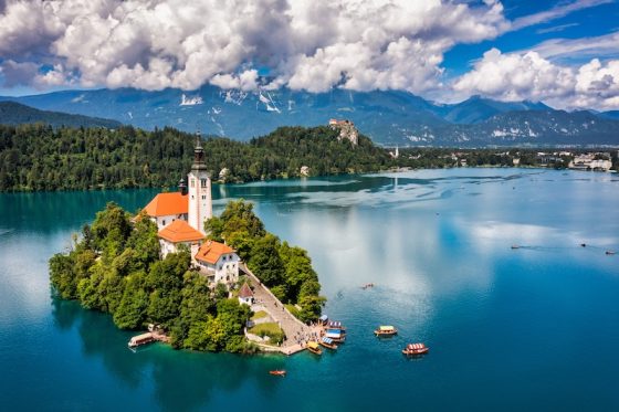 The island church and Bled Castle on Lake Bled, Slovenia, with the Julian Alps behind