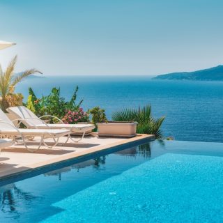 Sun loungers beside a villa infinity pool above the sea: the life the retirement savings gap seems to rule out, and living abroad can put back in reach