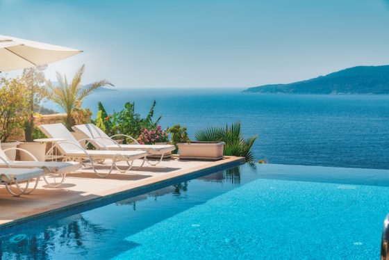 Sun loungers beside a villa infinity pool above the sea: the life the retirement savings gap seems to rule out, and living abroad can put back in reach