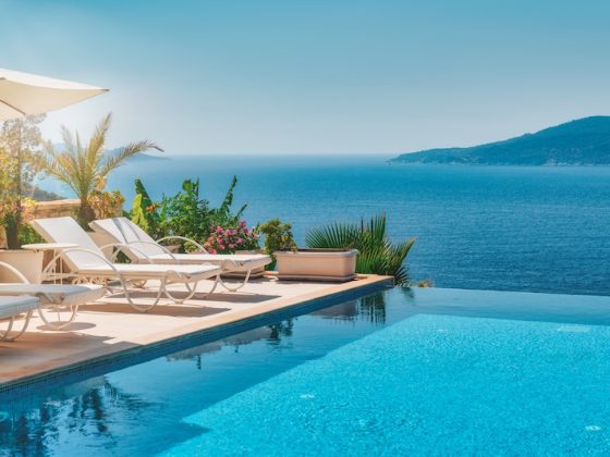 Sun loungers beside a villa infinity pool above the sea: the life the retirement savings gap seems to rule out, and living abroad can put back in reach